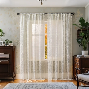 Off-white lace curtains with floral crochet patterns and elegant scalloped edges