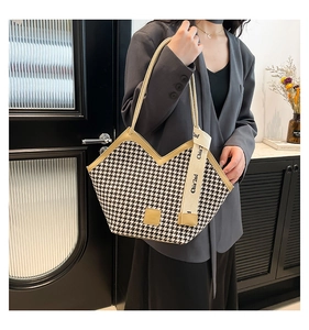 Detail of houndstooth tote bag featuring V-cut design and elegant brand ribbon accent