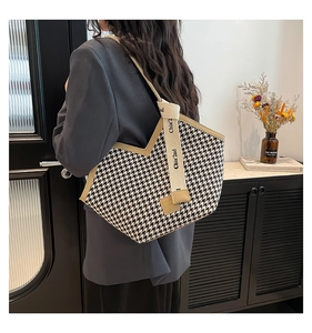 Detailed back view of a chic black and white houndstooth tote bag with canvas strap
