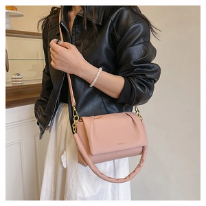 Detail of pink puffy handle bag with gold hardware and logo on leather crossbody flap