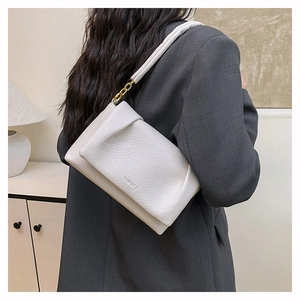 Detail of white lychee leather shoulder bag featuring gold chain link and logo texture