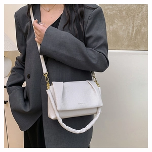 Close-up of white lychee pattern leather bag with ruched handle and shoulder strap