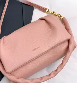 Close-up of pink lychee grain leather handbag with gold chain and Giorgio A logo