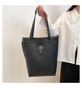 Detail of gothic embossed skull pattern and silver metallic skull hardware on black tote