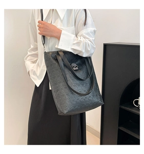 Close-up of gothic black tote bag with skull embossing and silver skull metal buckle