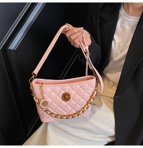 Detail of pink quilted leather bag with gold twist lock and chain strap on hand