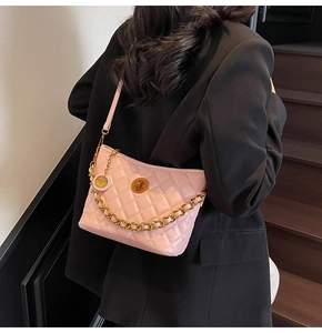 Detail of pink quilted crossbody bag featuring gold chain and turn-lock closure
