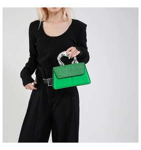Détail du sac bandoulière vert citron avec poignée métallique argentée et texture pailletée