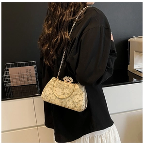 Détail du sac de soirée champagne doré avec fleurs en dentelle et fermoir couronne métal