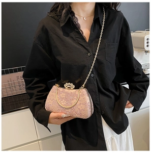 Détail de la pochette de soirée rose en dentelle avec strass et anse dorée