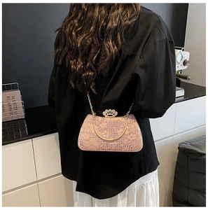 Détail d'une pochette de soirée en dentelle rose avec paillettes et fermoir couronne