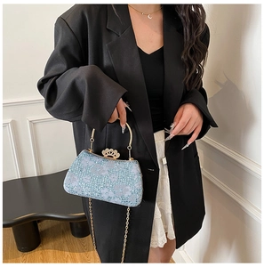 Détail du sac de soirée à paillettes bleu clair avec fermoir couronne dorée et fleurs