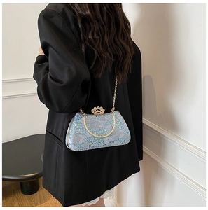 Détail du sac de soirée bleu clair avec fermoir couronne dorée et motifs à paillettes