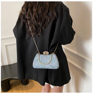 Détail du sac en dentelle bleu clair avec fermoir couronne dorée et poignée métallique