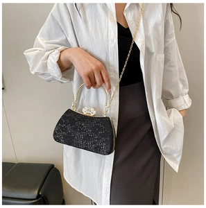 Détail de la pochette de soirée à paillettes noires avec poignée dorée sur mannequin