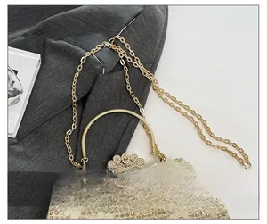 Détail de la bandoulière chaîne dorée et des paillettes sur le sac de soirée champagne