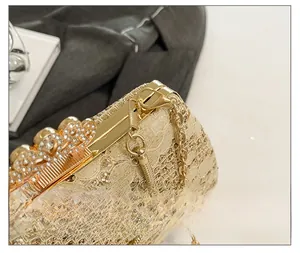 Détails macro d'une pochette en dentelle dorée avec fermoir couronne et cristaux
