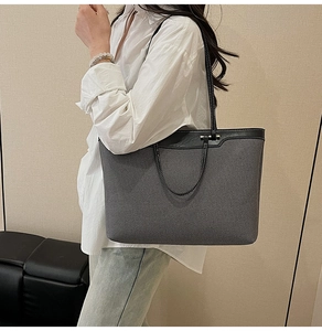 Close-up of contrast stitching on canvas and leather tote bag worn by model