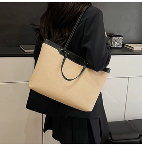 Detail of canvas tote bag showing contrast leather trim and white stitching craftsmanship