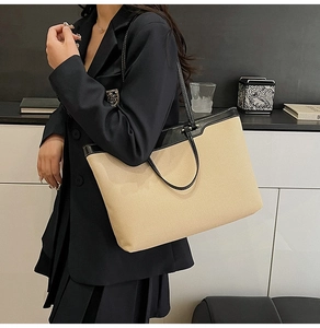 Detail of large contrast tote bag with beige canvas and black leather accents