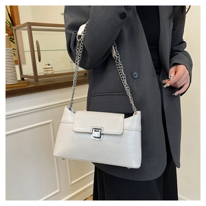 Détail du sac à bandoulière en cuir blanc crème avec chaîne argentée et fermoir