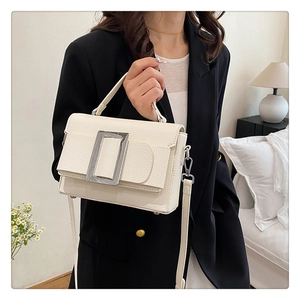 Detail of off-white lychee grain leather handbag with large silver rectangular metal buckle