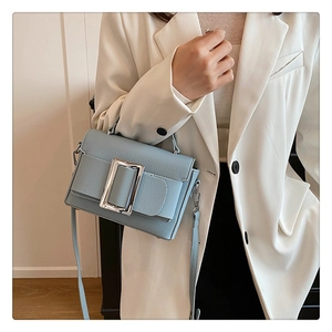 Close-up of light blue lychee pattern leather shoulder bag with silver metal buckle
