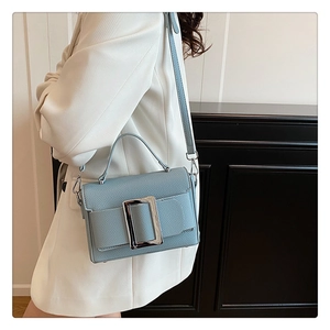 Close-up of light blue litchi pattern leather bag with a stylish silver square buckle