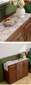Close-up of cream lace table runner with intricate floral crochet patterns on wood