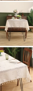 Detail of cream lace tablecloth with tulip jacquard patterns and elegant fringe edge