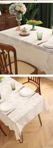 Detail of tulip lace embroidery with wavy scalloped edges on cream rectangle tablecloth