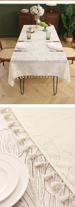 Close-up of cream lace tablecloth featuring tulip floral jacquard and delicate fringe trim
