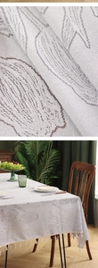 Close-up of vintage lace tablecloth with tulip embroidery and tassel trim detail