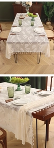 Close-up of French lace tablecloth with tulip embroidery and decorative ball tassel edges