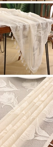 Close-up of French vintage white lace tablecloth with floral embroidery and tassel fringe
