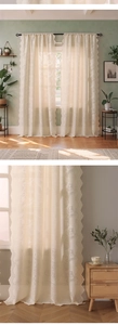 Detail of white tulip lace curtain with scalloped edges and floral embroidery texture