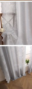 Detail of French tulip embroidery and wavy lace edge on white voile curtain fabric