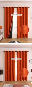 Detail of orange floral jacquard blackout curtain showing fabric texture and hanging rings