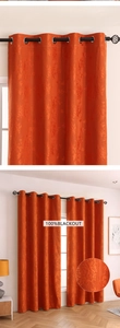 Detail of orange blackout curtain with damascus relief pattern and silver eyelets