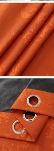 Detail of orange embossed jacquard fabric and black blackout layer with metal eyelets