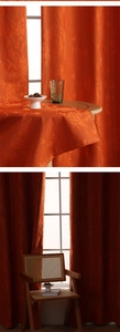 Close-up of orange jacquard blackout curtains with floral and butterfly patterns