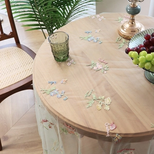 Transparent mesh round tablecloth with floral embroidery and text in a cozy home setting