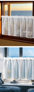 Detail of white cafe curtain with cat embroidery and pom-pom trim for windows