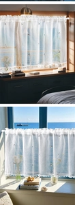 Detailed view of white sheer cafe curtain with cat embroidery and pom-pom lace trim