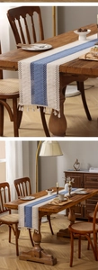 Detail of bohemian crochet table runner with navy stripes and cream tassel fringe