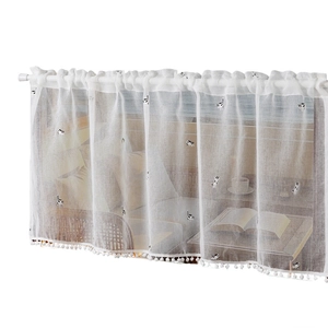 Translucent white cafe curtain with embroidered black and white cat patterns and pom-poms