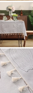 Close-up of tulip lace tablecloth showing detailed floral embroidery and white fringe tassels