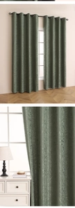 Detail of sage green blackout curtain with embossed leaf texture and silver metal grommets