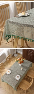 Detail of floral lace tablecloth with green tassel fringe and intricate hollow texture