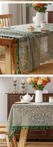 Detail of light green floral lace tablecloth with dark green tassel trim on a dining table